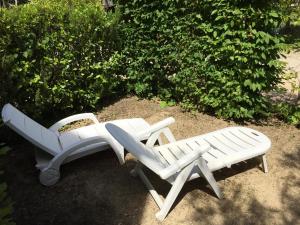 two white benches sitting next to each other at Résidence les Mûriers in Allegre Les Fumades