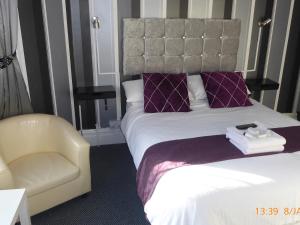 a hotel room with a bed and a chair at Rest and Welcome in Blackpool