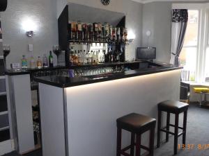 a bar with two stools in a room at Rest and Welcome in Blackpool