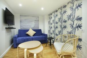 a living room with a blue couch and a table at Rent a Room - Cosy 2BDR in Paris