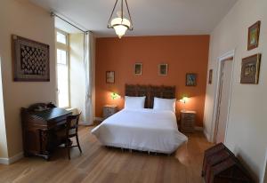 a bedroom with a white bed and a desk and window at La Résidence des Indes in La Rochelle