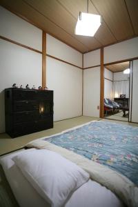 a bedroom with a large bed and a dresser at Demachi 2 in Kyoto