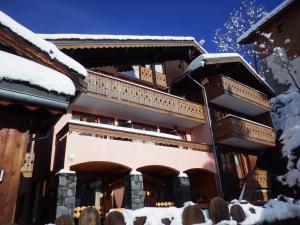 ein schneebedecktes Gebäude mit Leuten, die davor stehen in der Unterkunft Résidence Les Edelweiss in Champagny-en-Vanoise