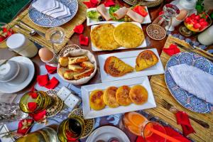 einen Tisch mit Teller mit Lebensmitteln darüber in der Unterkunft Riad Janate & SPA in Marrakesch