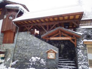 a stone building with a clock on the side of it at Résidence Les Edelweiss in Champagny-en-Vanoise