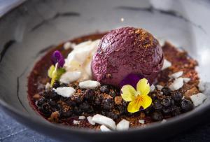 a dessert with purple ice cream and flowers in a bowl at Lapland Hotels Luostotunturi & Amethyst Spa in Luosto