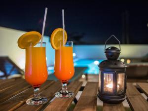 due bicchieri di succo d'arancia e una lanterna sul tavolo di Résidence Les Alizés a La Gaulette