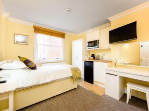 a bedroom with a bed and a desk with a computer at 1 Riverside Apartments in Norwich