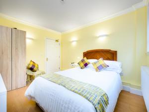 a bedroom with a large white bed and a chair at 1 Riverside Apartments in Norwich