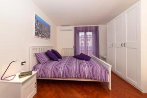 een slaapkamer met een bed met paarse kussens erop bij Villa Alida Casa Vacanze in Foligno