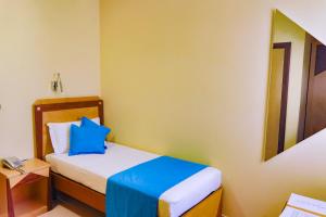 a bedroom with a bed with a blue pillow on it at Piccadilly Rooms Restaurant and Beach in Santa Maria al Bagno