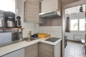 una piccola cucina con lavandino e forno a microonde di Roissy Appartements a Roissy en France