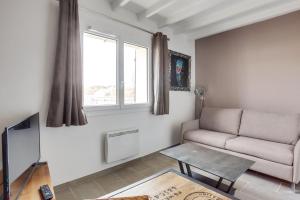 a living room with a couch and a table at Roissy Appartements in Roissy-en-France