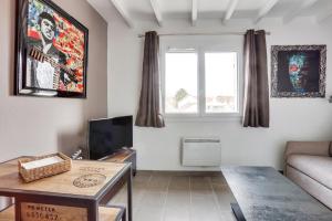 a living room with a couch and a table at Roissy Appartements in Roissy-en-France