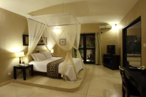 - une chambre avec un lit à baldaquin dans l'établissement The Dusun, à Seminyak