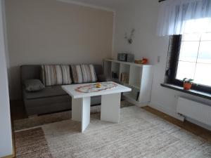 ein Wohnzimmer mit einem weißen Tisch und einem Sofa in der Unterkunft Ferienhaus Dampferblick in Meißen