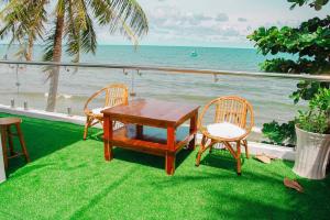 a table and chairs sitting on the grass near the ocean at sunset beach house 3 in Phu Quoc