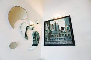 a mirror hanging on a wall next to a picture at Piccadilly Rooms Restaurant and Beach in Santa Maria al Bagno