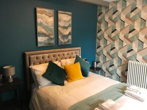 sypialnia z łóżkiem z żółtymi i zielonymi poduszkami w obiekcie No.16 w mieście Seaham