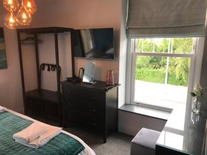 sypialnia z łóżkiem, komodą i oknem w obiekcie No.16 w mieście Seaham