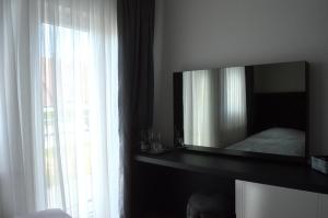 ein Schlafzimmer mit einem Spiegel, einem Bett und einem Fenster in der Unterkunft Rosbacher nun Residenz in Rosbach vor der Höhe