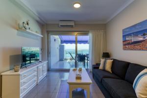 a living room with a couch and a tv at Amarre Bay in Puerto de Mogán