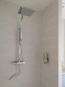a shower in a bathroom with a shower head at La Clé Du Maumont in Sainte-Féréole