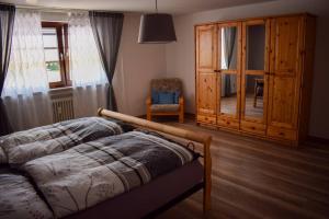 1 dormitorio con 1 cama, 1 silla y 1 armario en Eifel FEWO, en Hellenthal