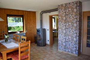 a kitchen with a table and a stone wall at Eifel FEWO in Hellenthal