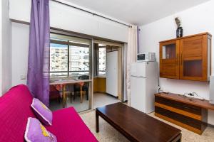 ein Wohnzimmer mit einem roten Sofa und einem Tisch in der Unterkunft Apartamento Montes Torremolinos in Torremolinos