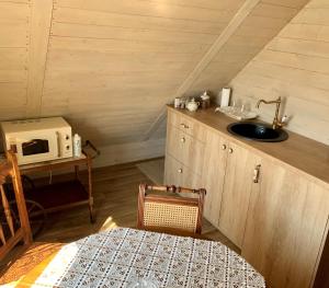 a small kitchen with a sink and a microwave at Arbatinės apartamentai in Biržai