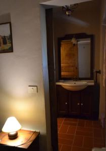 a bathroom with a sink and a lamp and a mirror at Agriturismo Selvapiana in Cantagallo