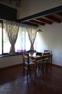 een eetkamer met een tafel, stoelen en ramen bij Agriturismo Selvapiana in Cantagallo