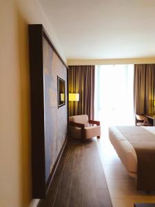 バタにあるPanafrica Hotel Boutique & Spaのベッドとソファ付きのホテルルーム