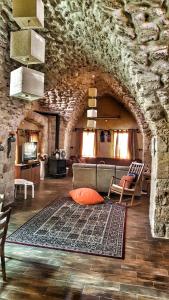 sala de estar con sofá y pared de piedra en 19th Century Magical House in Galilee, en ‘Eilabūn