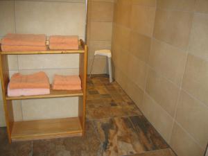 a bathroom with three shelves with orange towels at Ferienwohnung Kulla in Albstadt +7 photos