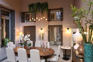 a dining room with a wooden table and white chairs at Marpessa Hotel & Spa in Agrinion