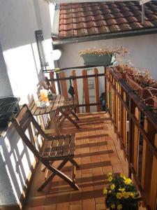 einen Balkon mit einem Holzstuhl und einem Tisch in der Unterkunft Ferienwohnung Konz in Merzig