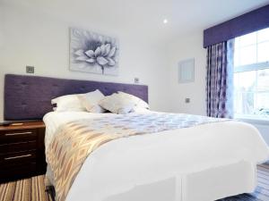 a white bedroom with a large bed and a window at The Rose and Crown in Thorpe le Soken +4 photos