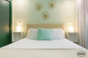 a bedroom with a bed with white sheets and pillows at Charming Gran Vía Center in Madrid