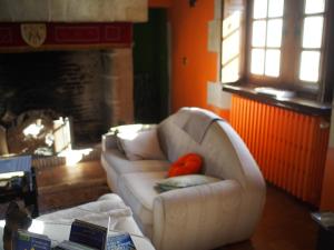 a living room with a white couch and a fireplace at Manoir du Rouvre in Mettray