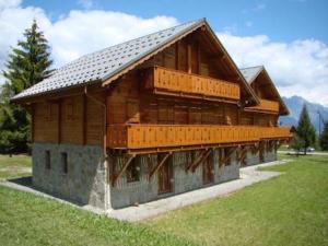 un gran edificio de madera en un campo de césped en Résidence Sourires et Vacances, en Saint-Pancrace