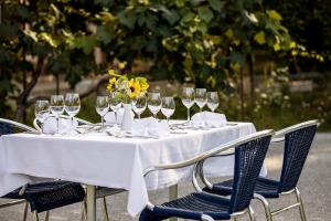 a table with wine glasses and yellow flowers on it at ODELYA - Stadthotel im Park in Basel