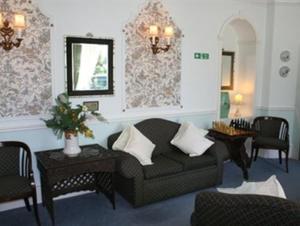 a living room with a couch and chairs and a mirror at Rosemullion Hotel in Falmouth