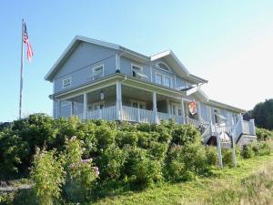 Ein blaues Haus auf einem Hügel mit amerikanischer Flagge in der Unterkunft Rosenhill B&B in Thalfang