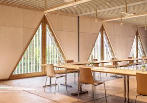a large room with tables and chairs and large windows at ODELYA - Stadthotel im Park in Basel