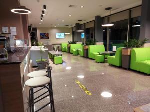 a waiting room with green chairs and tables in a store at Hotel Puldin COOP in Plovdiv
