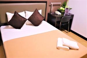 a bedroom with a bed with two towels on it at The Studio 18 Residences in Manila