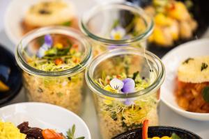 four glass jars filled with different types of food at ODELYA - Stadthotel im Park in Basel