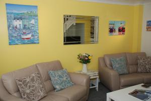 a living room with two couches and a table at Saltburn Holidays Jasmine Cottage Saltburn in Saltburn-by-the-Sea